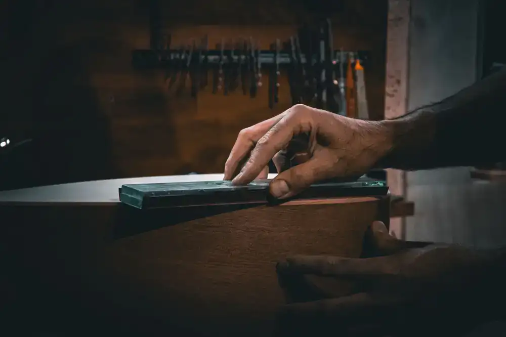 Close up view of hands sorting highly detailed marble tesserae on a wooden workbench