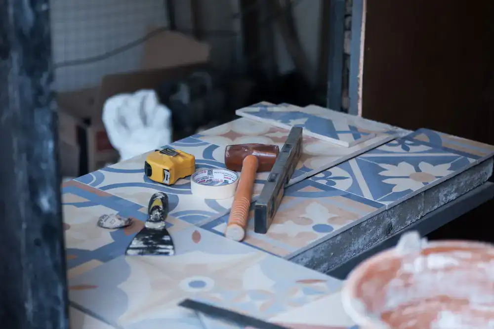 Studio workspace showing specialized restoration tools alongside historical tile fragments