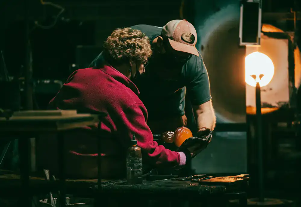 Instructor demonstrating traditional mosaic cutting techniques to a student